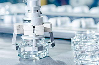 Production line of perfume bottles, visual illustrating the "Producing sustainably" pillar of the programme "Sharing Beauty With All".